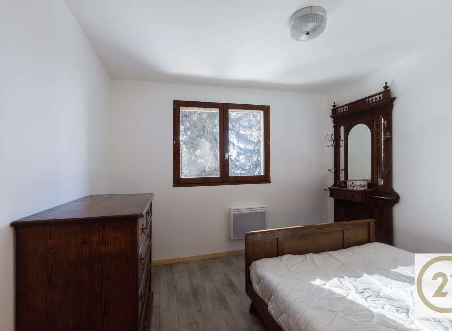 This charming bedroom features a classic design with a wooden bed frame and dresser, creating a warm and inviting atmosphere.