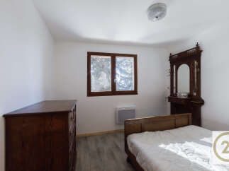 This charming bedroom features a classic design with a wooden bed frame and dresser, creating a warm and inviting atmosphere.
