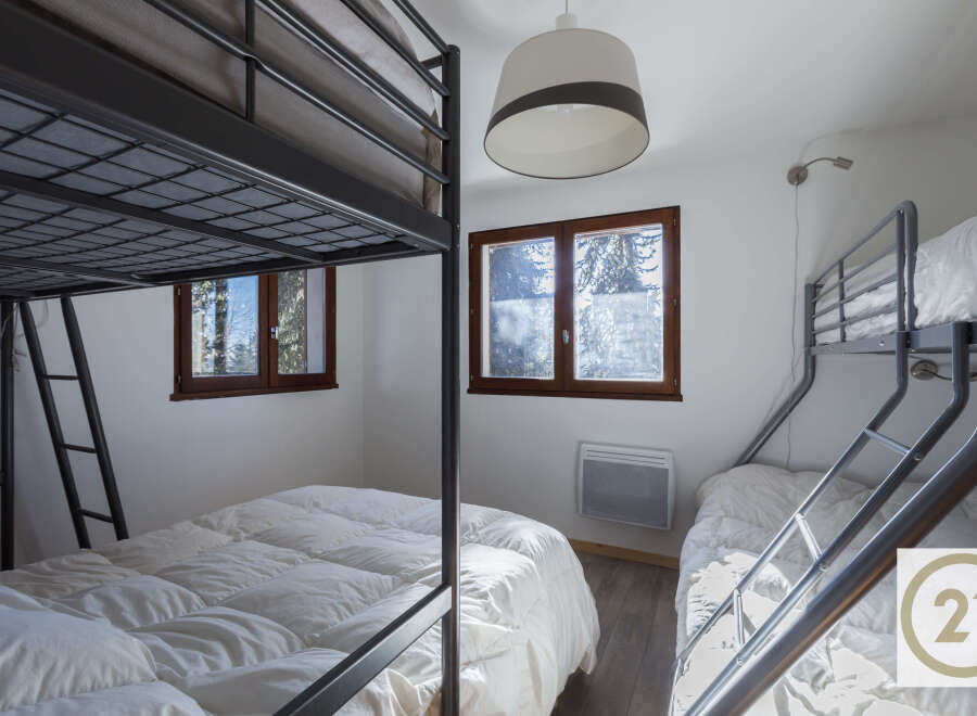 This cozy bedroom features two bunk beds, perfect for accommodating multiple guests or family members.