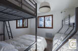 This cozy bedroom features two bunk beds, perfect for accommodating multiple guests or family members.