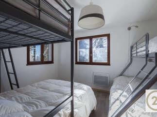 This cozy bedroom features two bunk beds, perfect for accommodating multiple guests or family members.