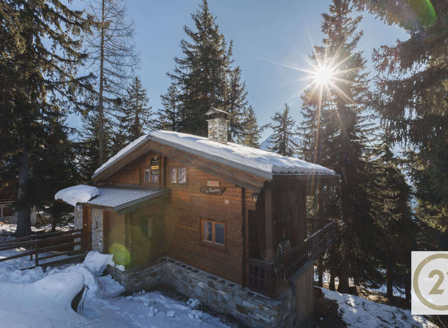 Nestled amidst a snowy landscape, this charming wooden chalet offers a cozy retreat.