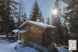 Nestled amidst a snowy landscape, this charming wooden chalet offers a cozy retreat.