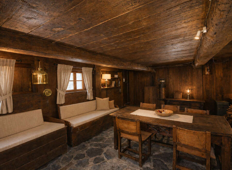 Experience rustic charm in this cozy dining area, featuring a large wooden table perfect for gatherings and built-in wooden benches with comfortable seating.