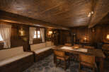 Experience rustic charm in this cozy dining area, featuring a large wooden table perfect for gatherings and built-in wooden benches with comfortable seating.