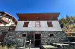 Discover this charming property featuring a unique stone facade and wooden accents, exuding rustic elegance.