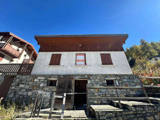 Discover this charming property featuring a unique stone facade and wooden accents, exuding rustic elegance.