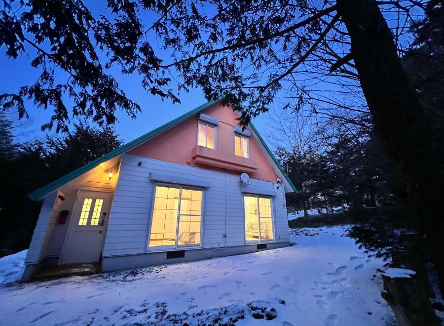 Nestled in a serene, snow-covered landscape, this charming house offers a cozy retreat.