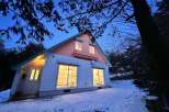 Nestled in a serene, snow-covered landscape, this charming house offers a cozy retreat.