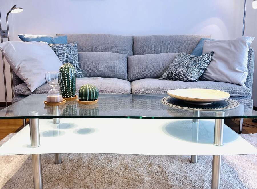 This cozy living room features a modern glass coffee table, perfect for entertaining or relaxing.