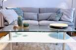 This cozy living room features a modern glass coffee table, perfect for entertaining or relaxing.
