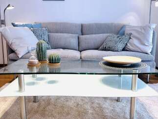 This cozy living room features a modern glass coffee table, perfect for entertaining or relaxing.