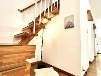 This stunning property features a beautifully crafted wooden staircase, adding a touch of elegance to the interior.
