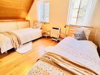This cozy bedroom features two twin beds with stylish bedding and soft throws, perfect for a comfortable stay.