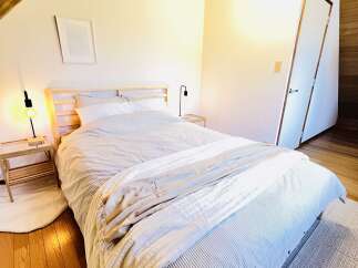 This cozy bedroom features a comfortable bed with a striped comforter and a soft blanket, perfect for a relaxing retreat.