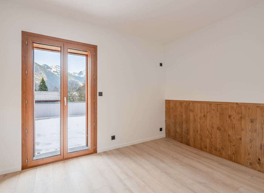 This stunning property boasts a bright and airy interior, perfect for enjoying the breathtaking mountain views visible through the large windows.