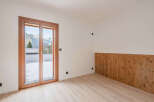This stunning property boasts a bright and airy interior, perfect for enjoying the breathtaking mountain views visible through the large windows.