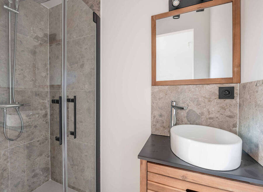This modern bathroom features a sleek shower with glass doors and a stylish vanity.