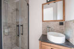 This modern bathroom features a sleek shower with glass doors and a stylish vanity.
