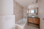 This modern bathroom features a sleek design with a bathtub and a stylish vanity.