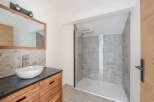 This modern bathroom features a sleek design with a spacious walk-in shower and a stylish vanity.