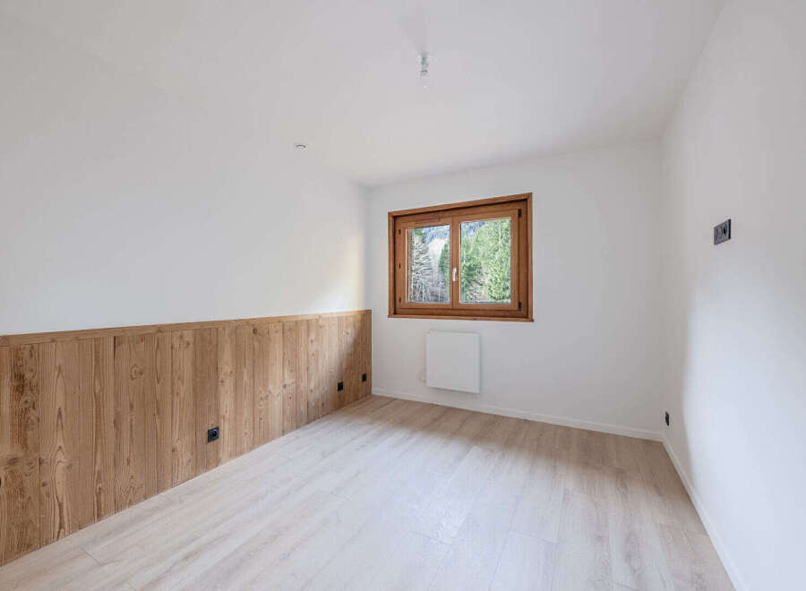 Discover the charm of this inviting room, featuring a beautiful wooden accent wall and a bright, airy atmosphere.