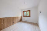 Discover the charm of this inviting room, featuring a beautiful wooden accent wall and a bright, airy atmosphere.