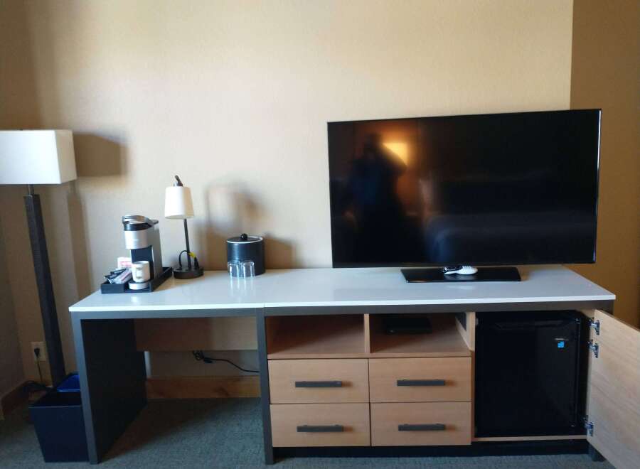 This hotel room features a modern entertainment center with a large flat-screen TV, perfect for relaxing after a long day.