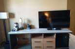 This hotel room features a modern entertainment center with a large flat-screen TV, perfect for relaxing after a long day.