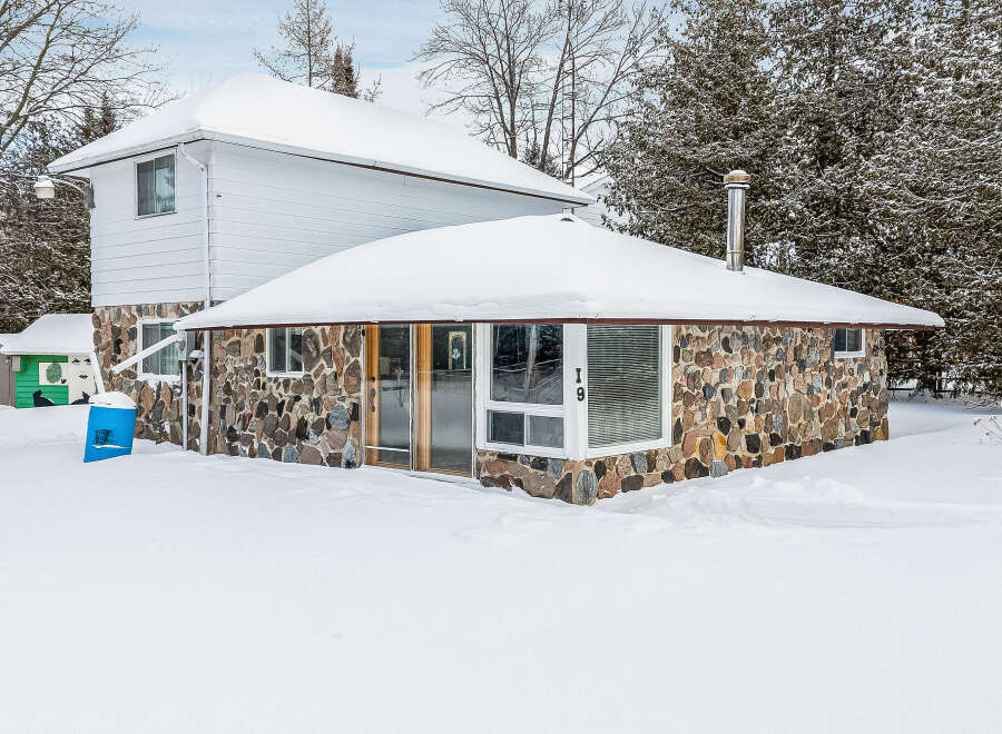 This charming stone-clad home offers a unique blend of rustic charm and modern comfort.