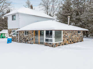 This charming stone-clad home offers a unique blend of rustic charm and modern comfort.