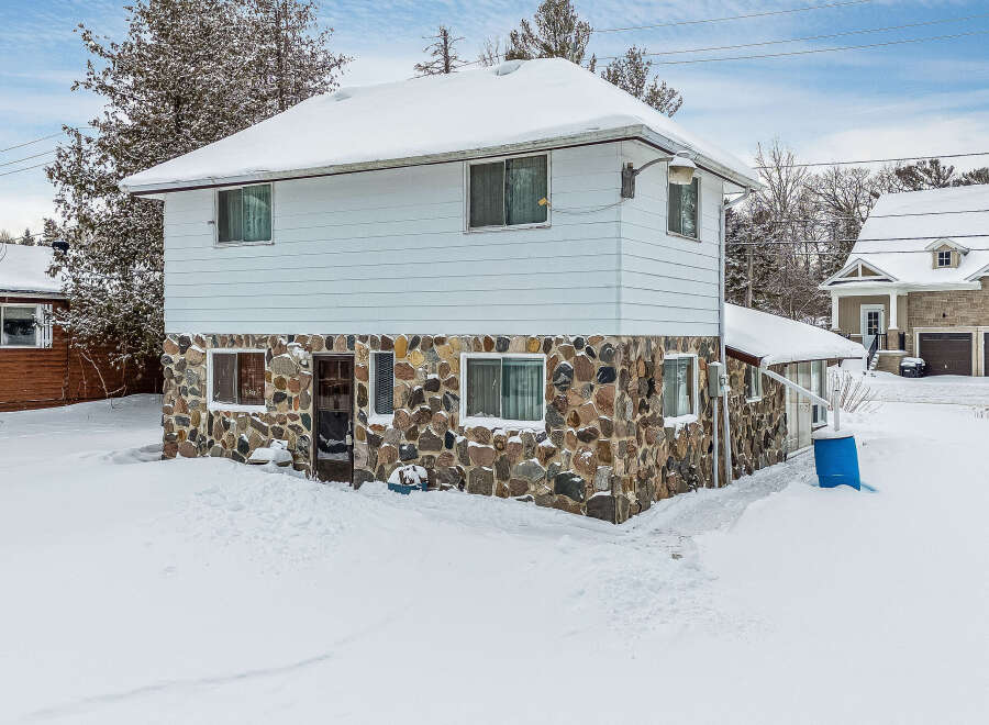 This charming two-story home boasts a unique stone facade on the lower level, offering a rustic and inviting curb appeal.