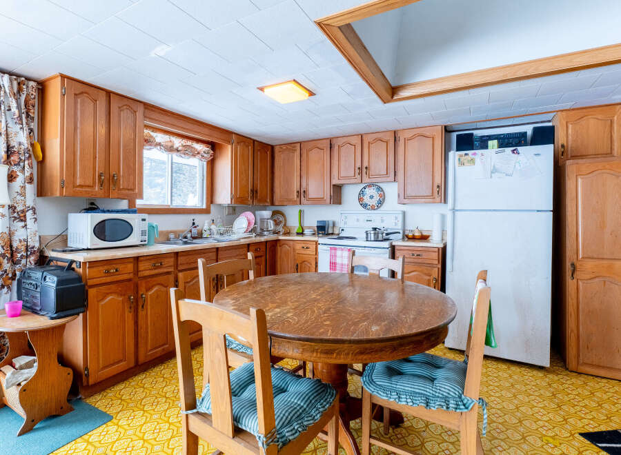 Step into this charming kitchen, featuring classic wooden cabinetry and a cozy dining area.