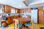 Step into this charming kitchen, featuring classic wooden cabinetry and a cozy dining area.