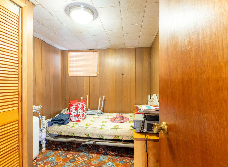 This cozy room features wood paneling and a comfortable bed, perfect for a guest room or a small living space.