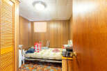 This cozy room features wood paneling and a comfortable bed, perfect for a guest room or a small living space.