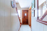 Step into this inviting entryway, featuring a warm wooden door and a charming staircase.