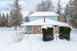 This charming property boasts a cozy exterior with a stone facade and a snow-covered roof, perfect for winter.