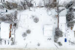 This aerial view showcases a snow-covered property, highlighting the winter landscape and the architectural details of the houses.