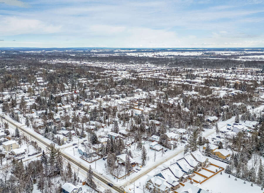 This aerial view showcases a snow-covered residential area, perfect for those seeking a winter wonderland.