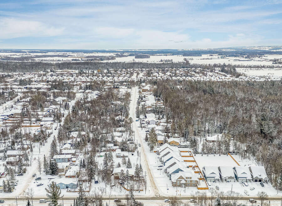 Discover the charm of this snow-covered neighborhood, featuring a variety of homes nestled amidst a winter wonderland.