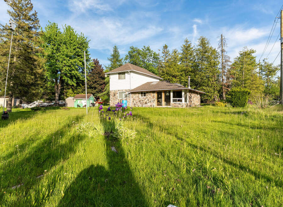 Discover this charming property featuring a unique stone-accented home nestled amidst lush greenery and mature trees.