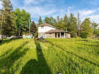 Discover this charming property featuring a unique stone-accented home nestled amidst lush greenery and mature trees.