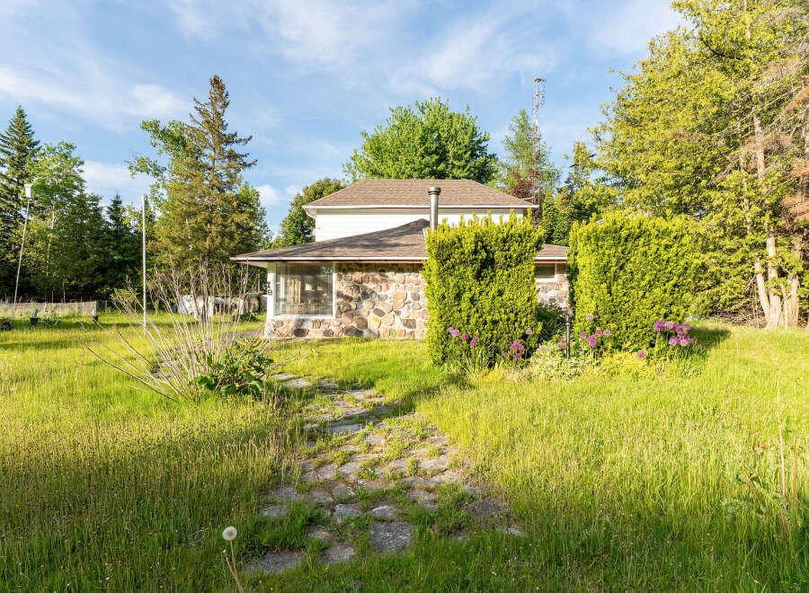 Discover this charming home featuring a unique stone facade and a welcoming stone pathway leading to the entrance.