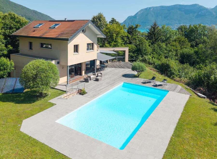 This stunning property boasts a luxurious outdoor pool and a spacious wooden deck, perfect for relaxation and entertaining.