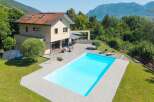 This stunning property boasts a luxurious outdoor pool and a spacious wooden deck, perfect for relaxation and entertaining.
