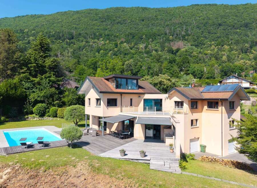 This stunning property boasts a luxurious outdoor space, complete with a sparkling pool and a spacious wooden deck, perfect for entertaining or relaxing.