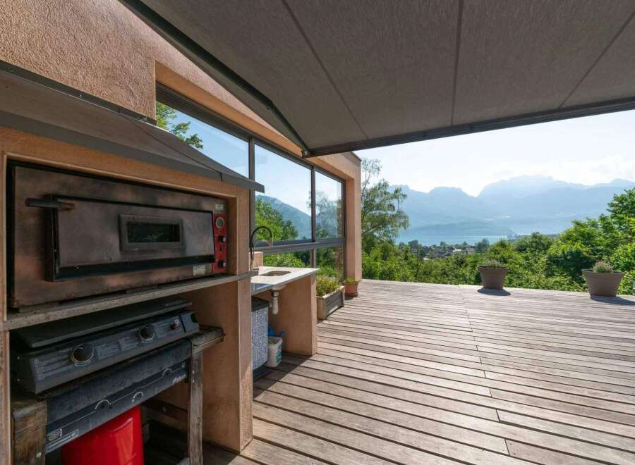 Enjoy breathtaking views from this stunning outdoor kitchen! Featuring a pizza oven, cooktop, and sink, this space is perfect for entertaining.