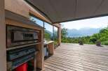 Enjoy breathtaking views from this stunning outdoor kitchen! Featuring a pizza oven, cooktop, and sink, this space is perfect for entertaining.