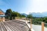 Enjoy breathtaking views from this stunning property! This home features a spacious wooden deck with glass railings, perfect for outdoor relaxation and entertaining.